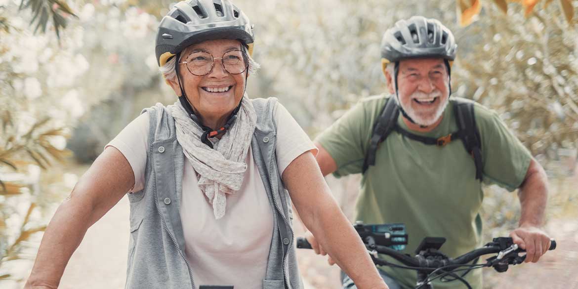Man and Woman riding bikes wearing helmets. 