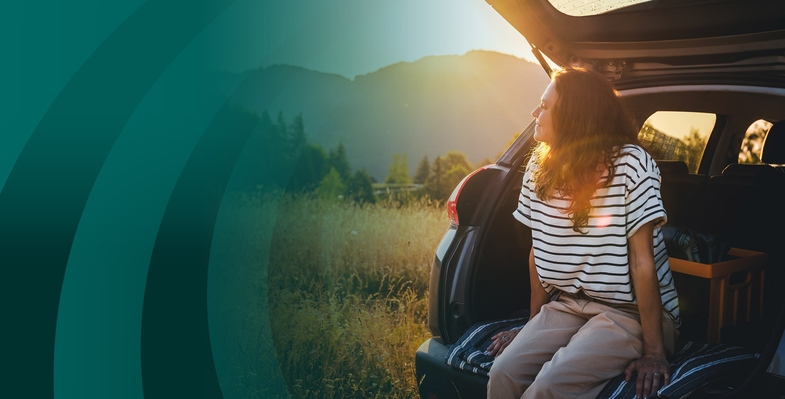 Woman sitting on trunk during sunset.