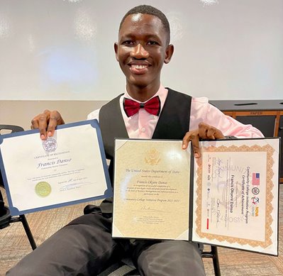 Francis in bow tie holding two degrees.