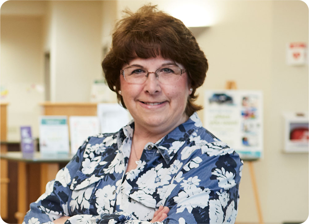 Woman in blue and white flower shirt inside a Community First Credit Union location.