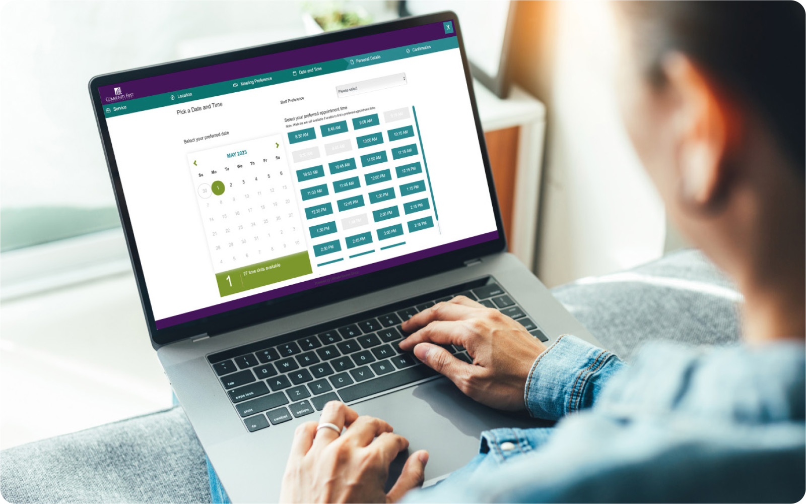 Woman with laptop reviewing appointment scheduling at Community First Credit Union.