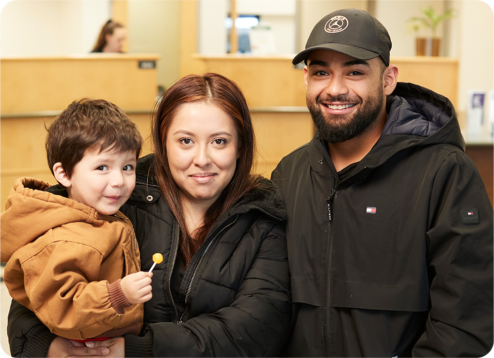 Man, woman, and child with sucker at Community First Credit Union location.