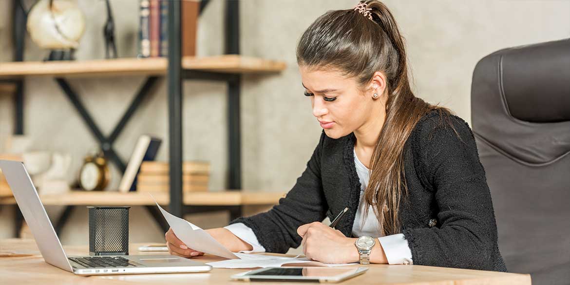 Woman in black sweater reviewing Roth IRA statement.