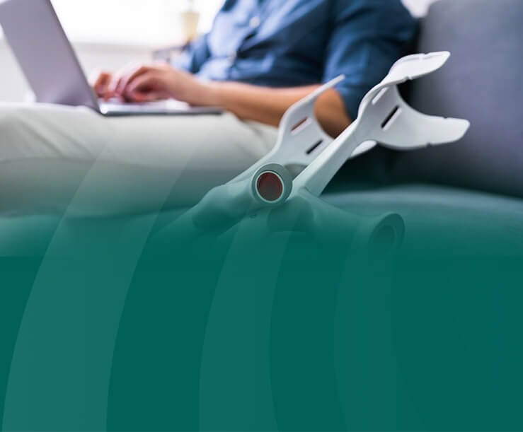 Man with laptop and crutches, green background.