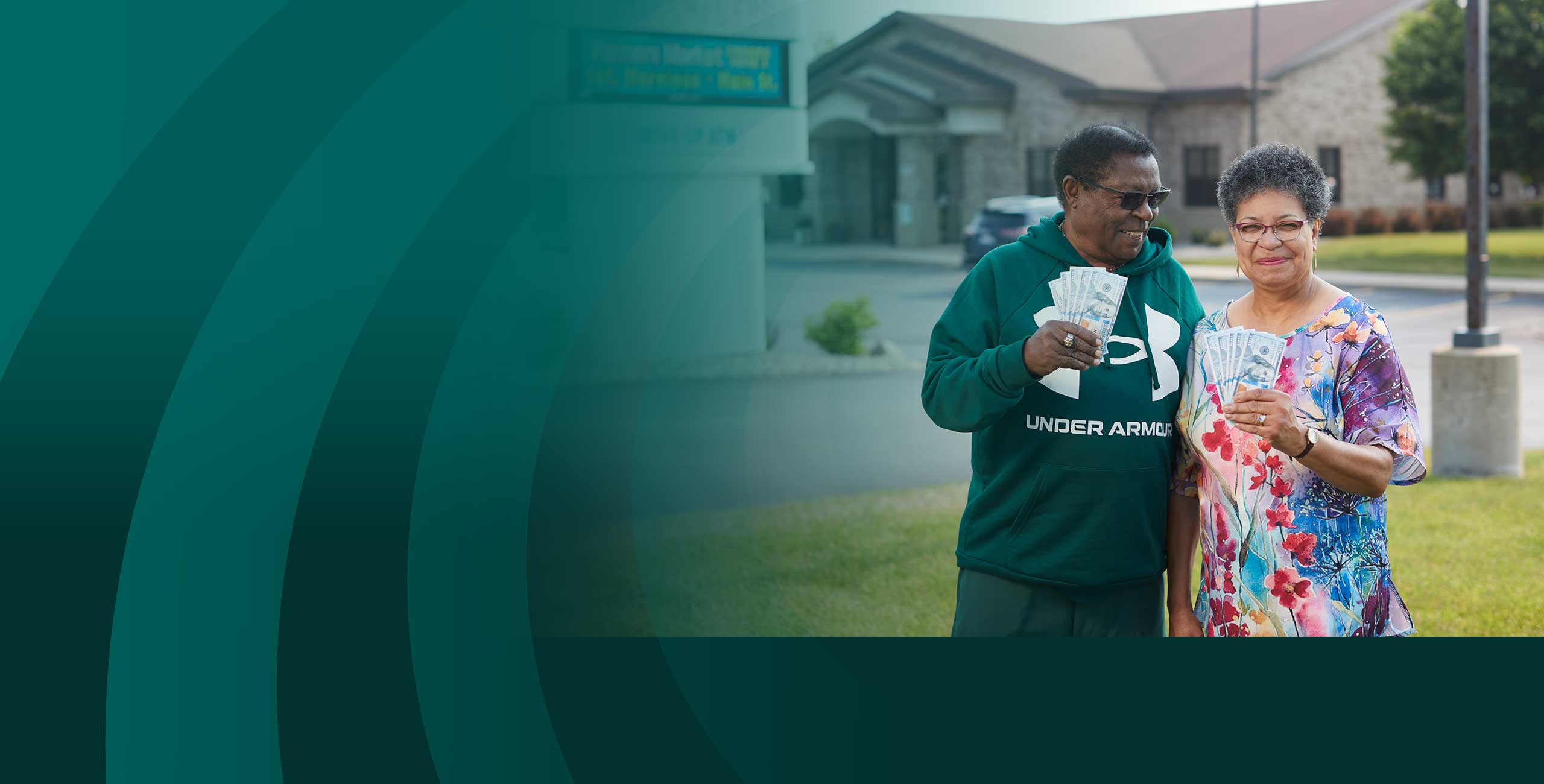 Couple holding up money while saving at Community First Credit Union