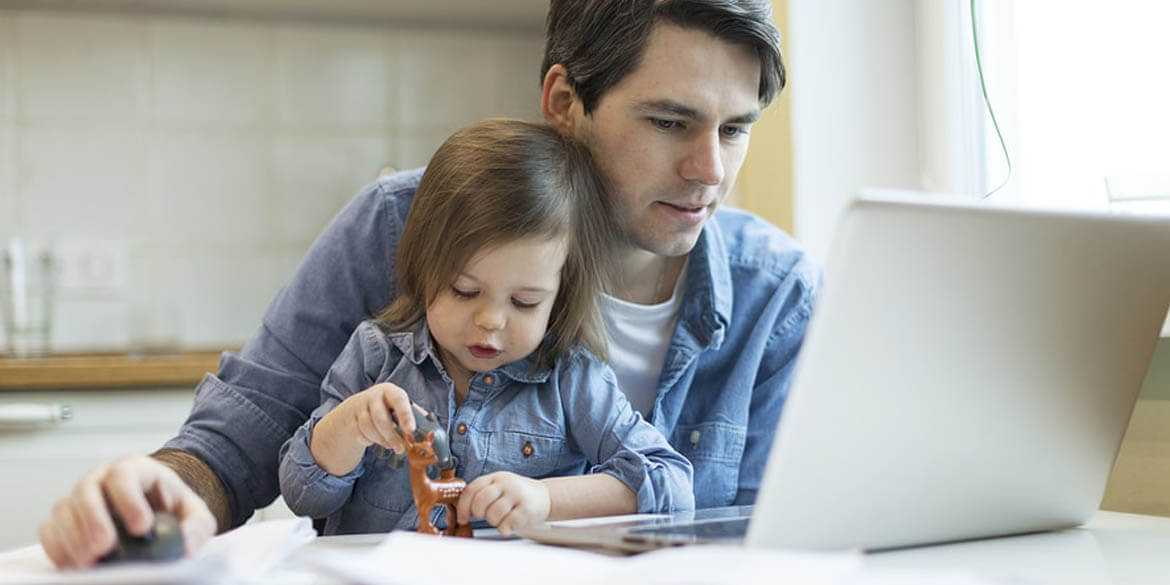 Dad and young daughter with open laptop and bills.