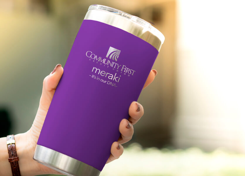 hand holding a purple CFCU Yeti mug.