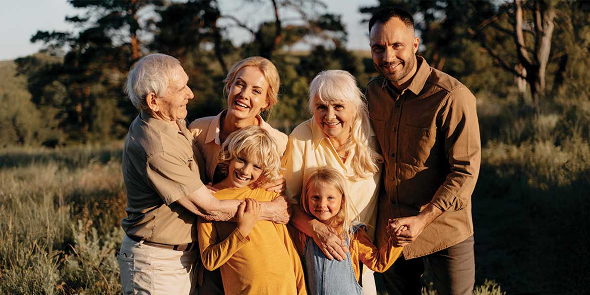 Multi-generational family hugging in the sunshine.