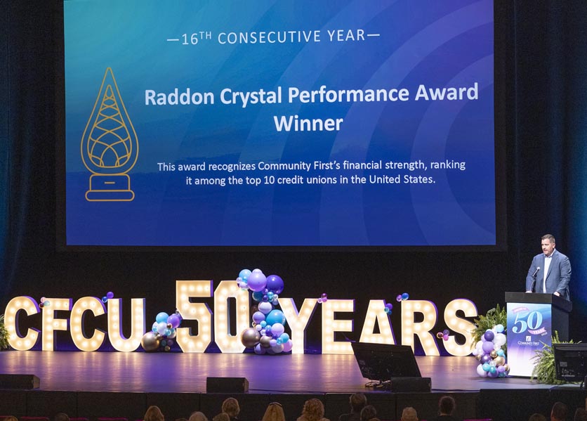 CFCU Annual Meeting stage showing 50 years and 16th Annual Crystal Raddon Performance Award