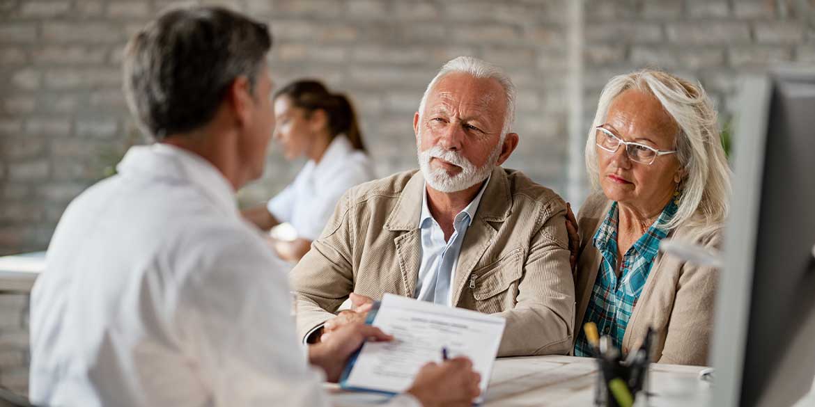 A retiring couple talking with a financial advisor on social security benefits