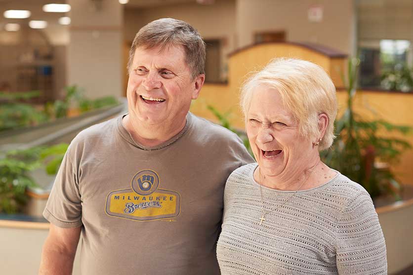 Grandparents smiling in a Community First Credit Union branch checking out CDs and IRA options