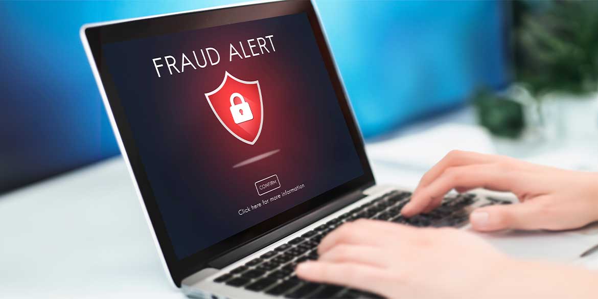 Person typing on a computer protecting themselves from fraud