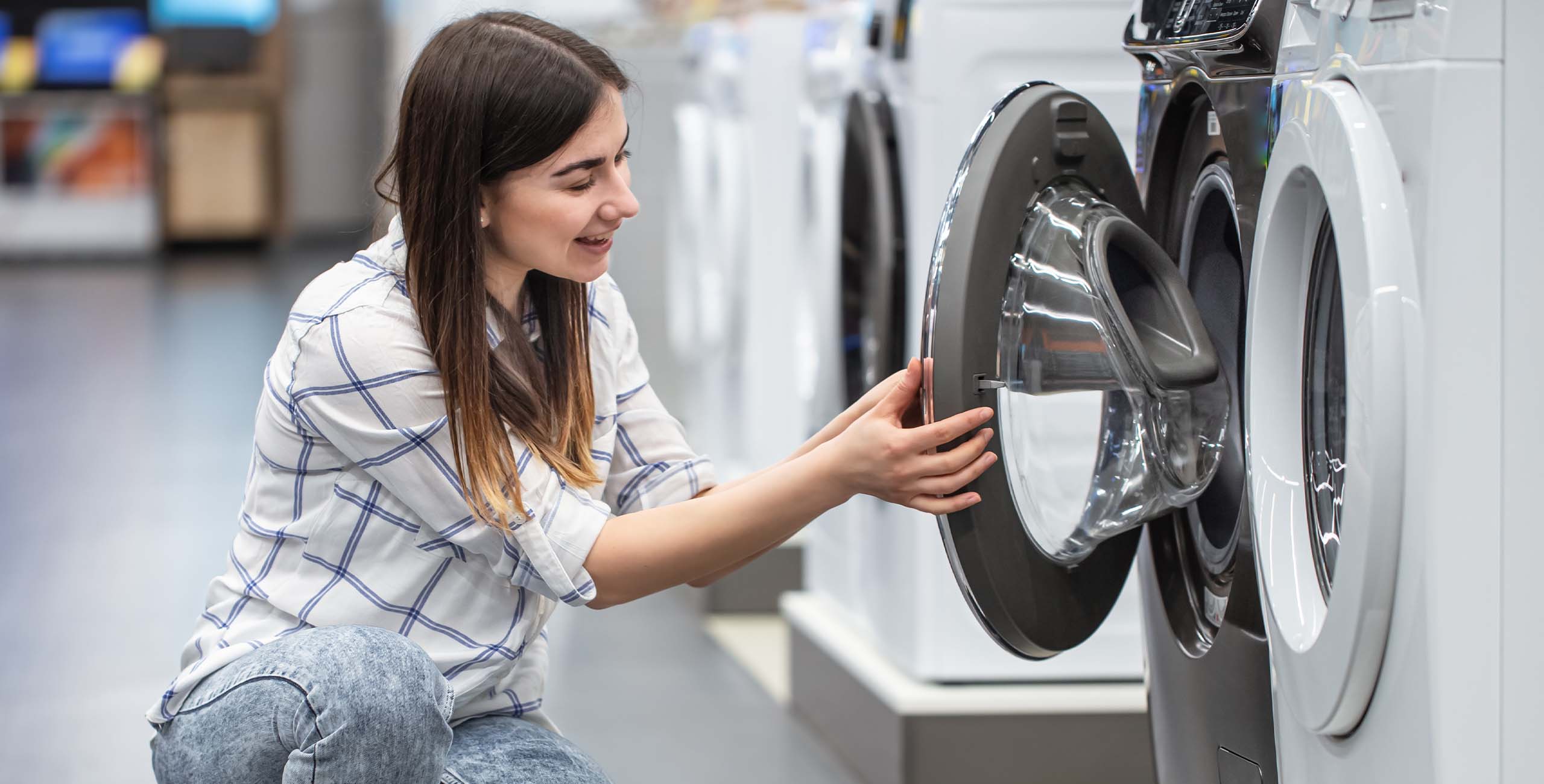 Woman in front of white washing machine.