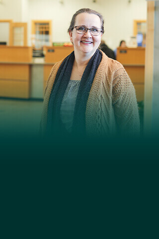 Woman in brown sweater and black scarf in Community First Credit Union, Oshkosh Wisconsin banking.