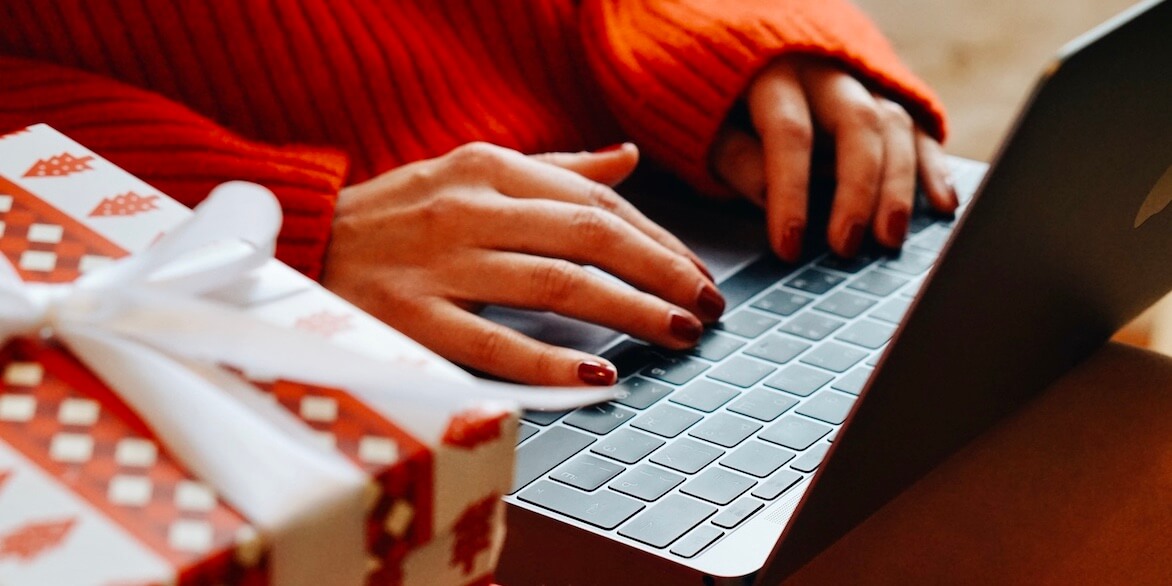 Woman safe holiday shopping online using laptop.