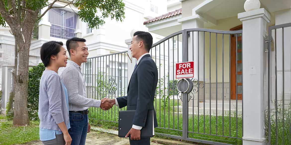 Couple closing on condo sale with real estate agent.