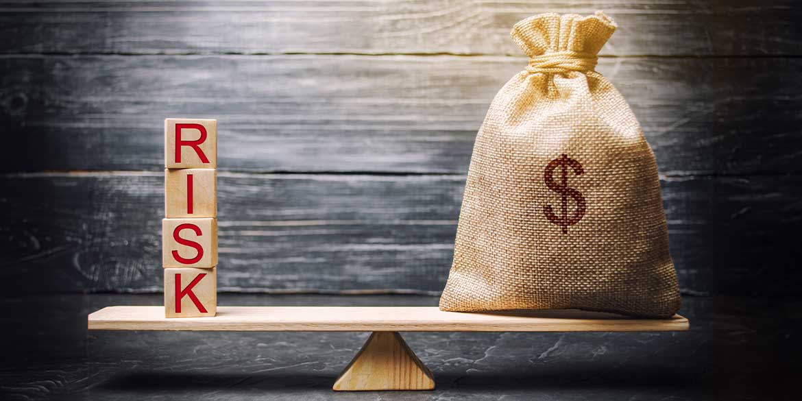 A bag of money with a dollar sign and to the left of it are blocks with the letters spelling R-I-S-K