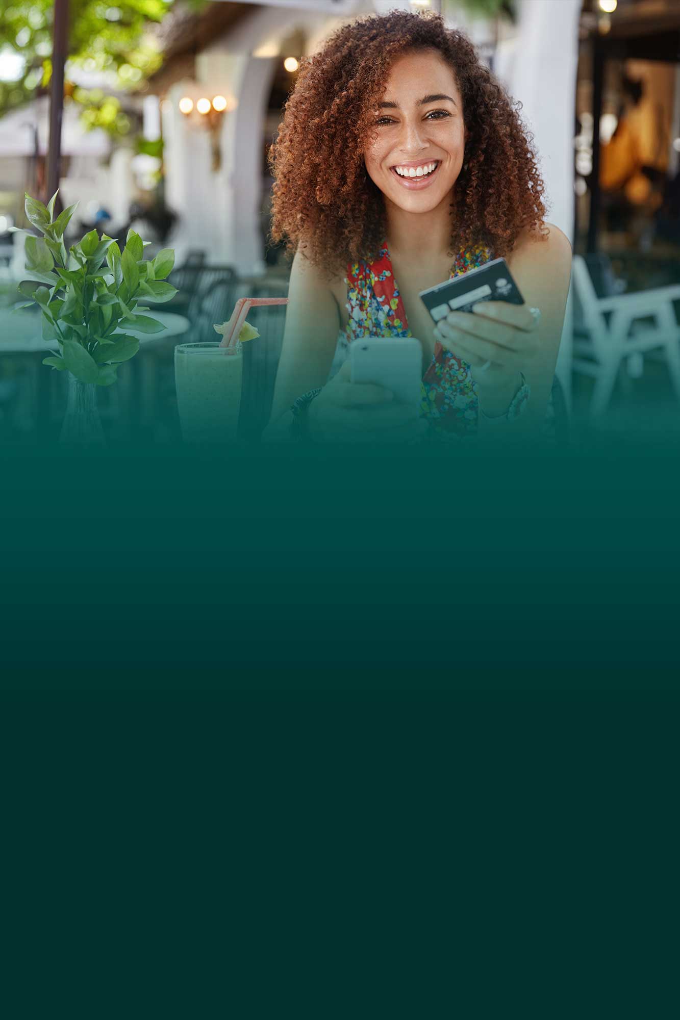 Smiling woman at a restaurant paying with a debit check card