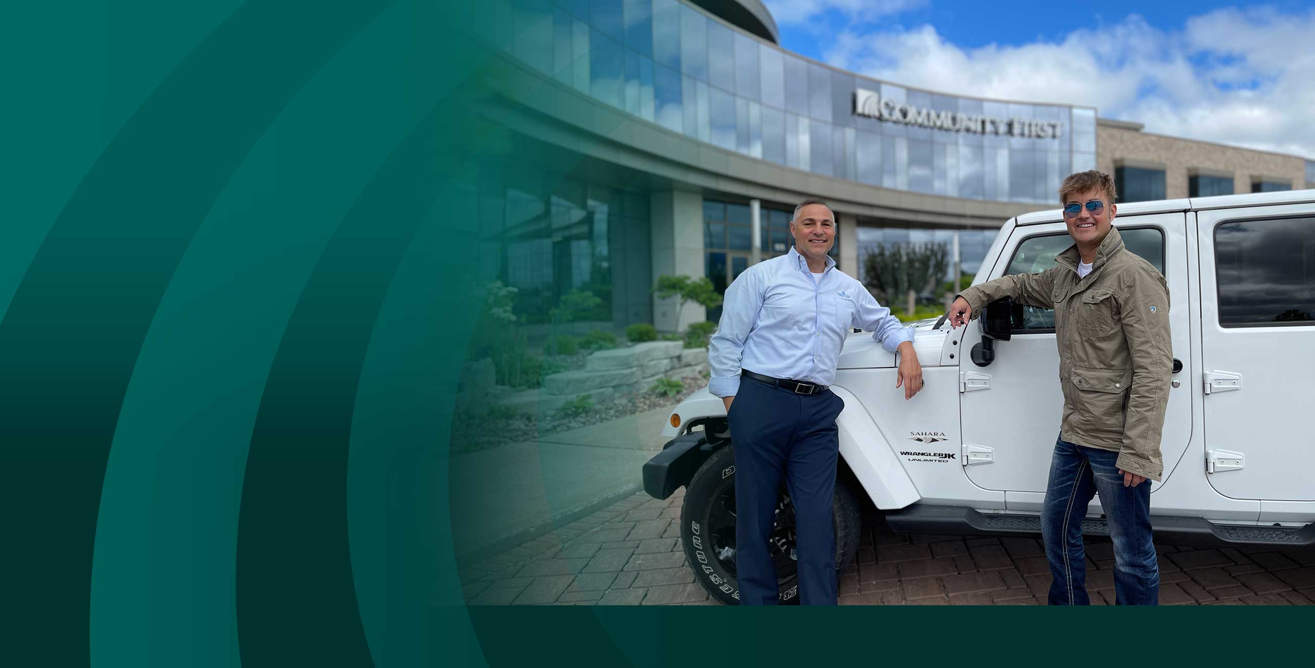 Two men standing in front of a jeep in front of a Community First Credit Union branch having just got a vehicle loan