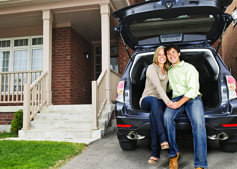 couple in car by house.