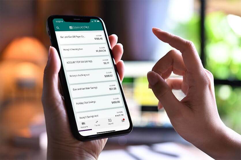 CFCU digital banking on mobile with hands holding device in store and ready to tap.