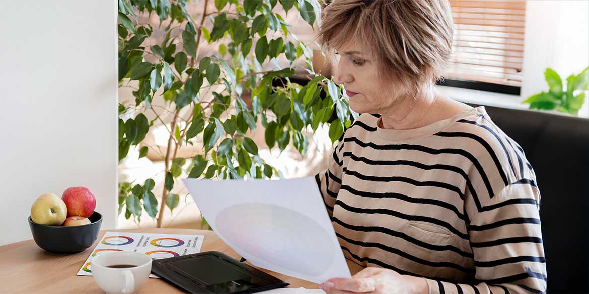 Woman in striped shirt holding retirement statement.