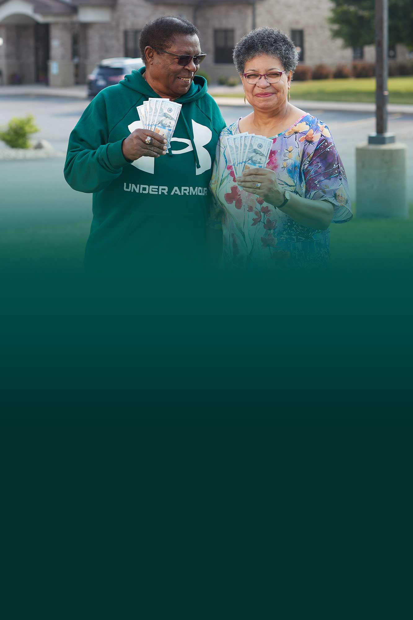 Couple holding up money while saving at Community First Credit Union