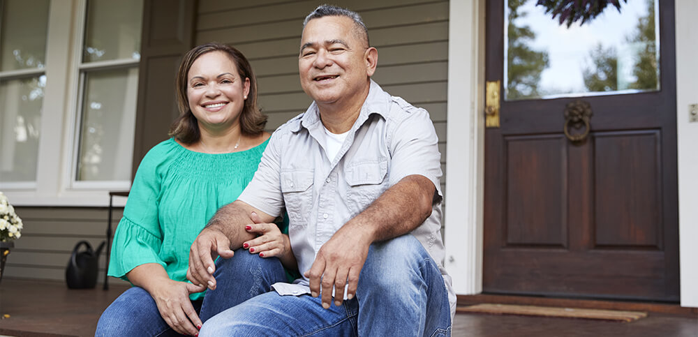 couple sitting outside of home.