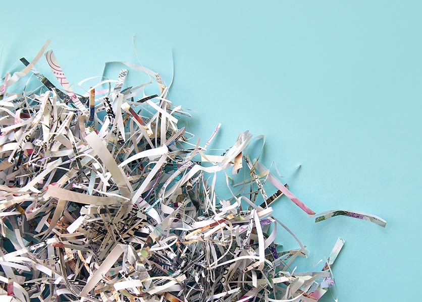 Shredded secure documents  with a light blue background showcasing CFCU shred events.