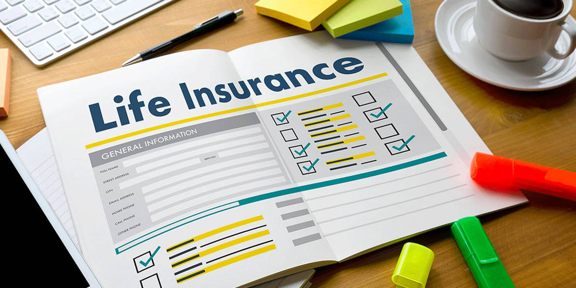 Document with check marks and Life Insurance in blue block letters at top on desk with highlighters, pens, post-it notes and a cup of coffee.