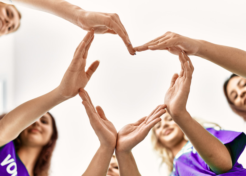 Girls with hands in the shape of hearts.