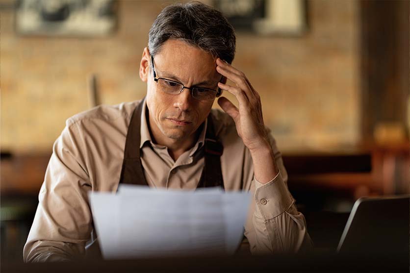 Man with glasses looking at papers.