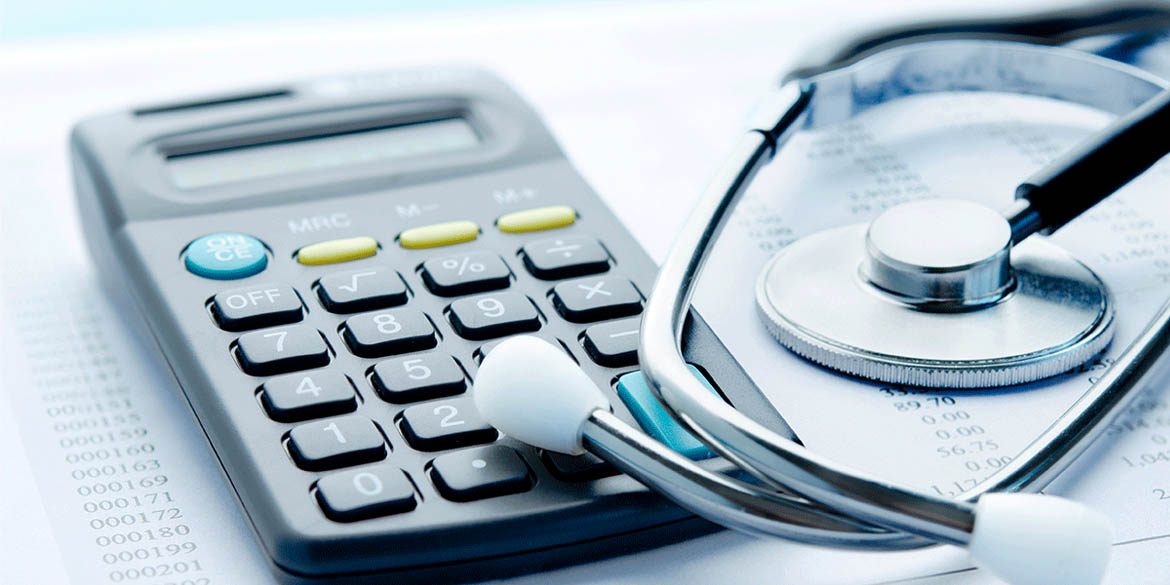 Calculator and stethoscope on top of medical bill.