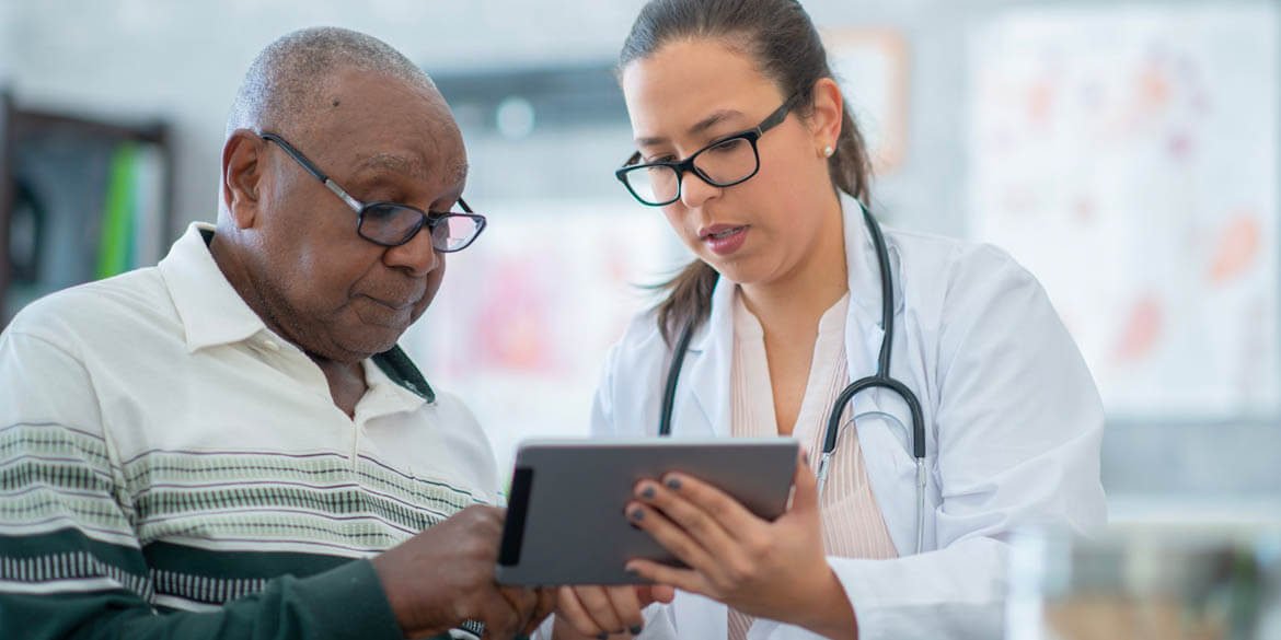 Doctor and patient looking at tablet discussing health care costs in retirement.