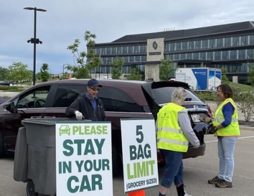 CFCU member shred event with three volunteers collecting recycling from vehicle.